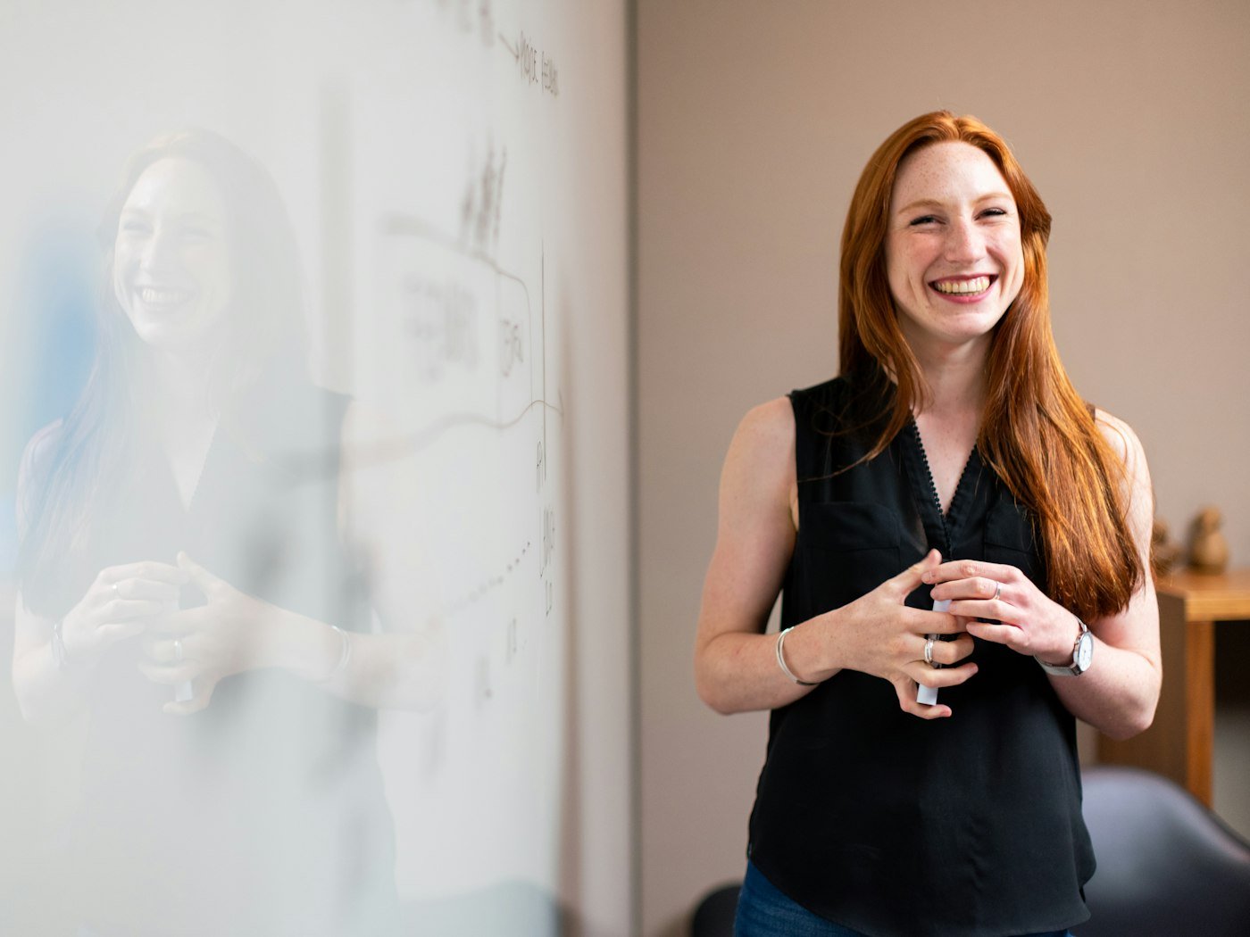 A woman speaking confidently while presenting at a whiteboard